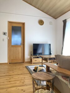 豊橋市の新築住宅リビング。木の床と扉、テレビ台のある落ち着くデザイナー住宅風空間。